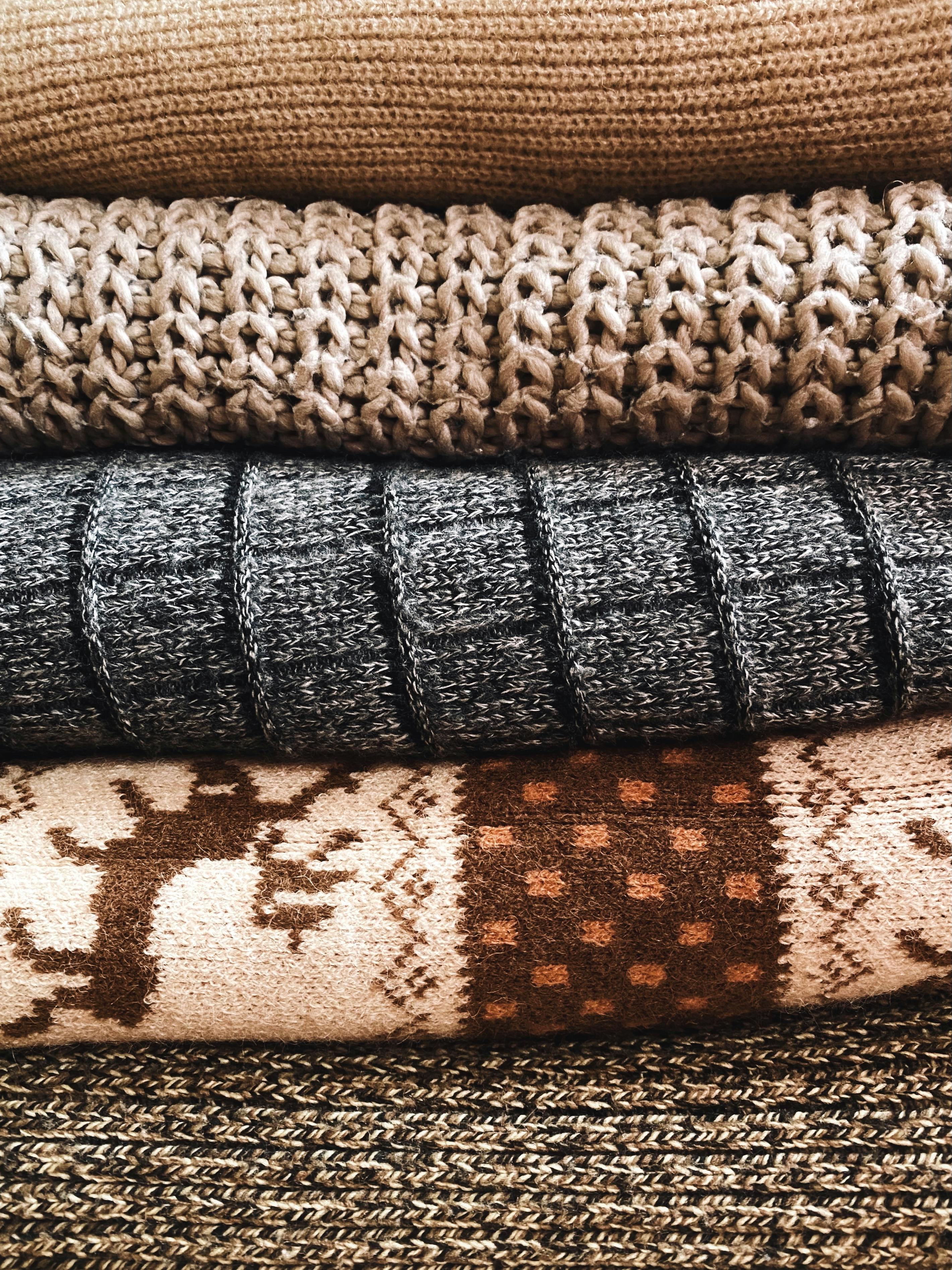 pexels-photo-13771344-13771344 Stack of warm, knitted wool textiles showcasing intricate patterns and textures, perfect for cozy decor or fashion.